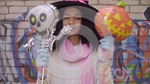 Cute black teen girl in witch hat posing faces on Halloween