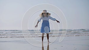 Cute Black woman girl in straw hat playing at seashore barefoot.