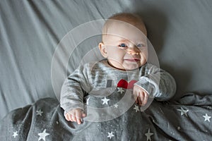 cute blond baby with blue eyes, baby laying on bed, view from above