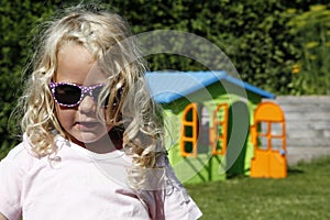 Cute blond girl with playhouse