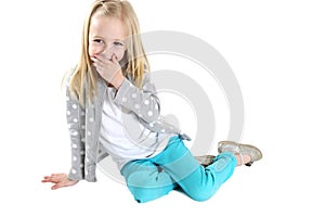 Cute blond girl sitting hand to mouth laughing