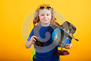 Cute blond kid wearing explorer hat and backpack on studio. Child explorer and adventure concept. Kid tourists hold