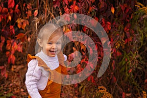 Cute blond little girl in yhe yard with red grapes