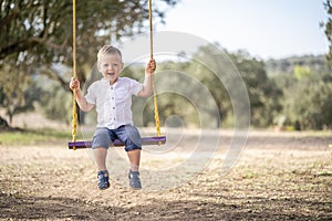 Cute blond toddler on the swing