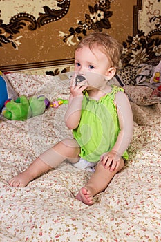 Cute blonde baby girl with beautiful blue eyes sitting and smiling with toy