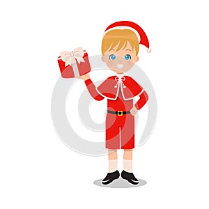 Cute blonde boy holding a gift while wearing Christmas costume.