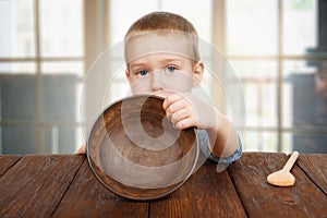 Cute blonde boy shows empty plate