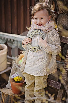 Cute blonde child girl having fun in early spring garden