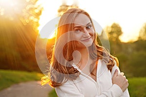 Cute blonde girl on background of sun. Ordinary happy woman enjoying life in summer