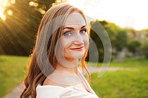 Cute blonde girl on background of sun. Ordinary happy woman enjoying life in summer