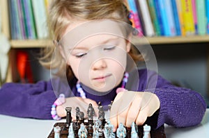 Cute, blonde girl playing chess