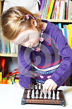 Cute, blonde girl playing chess