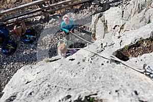 Cute blonde girl rock climbing using top rope with her mother protecting her.