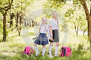 Cute blonde girls in school uniform, in white golfs and backpacks photo