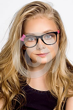 Cute blonde little girl in glasses on a white background in the