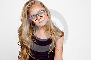 Cute blonde little girl in glasses on a white background in the