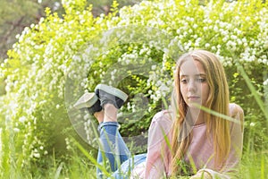 Cute blonde teenage-girl dreaming on a sunny day on the grass