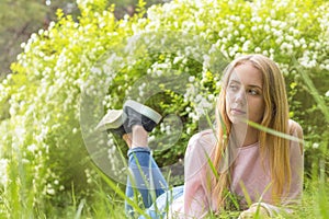 Cute blonde teenage-girl dreaming on a sunny day on the grass