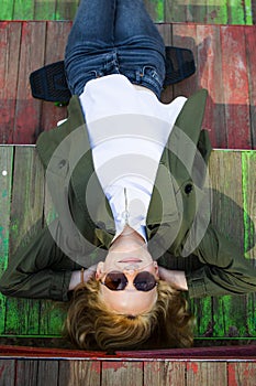 Cute Blonde Teenager Girl Relaxing In Park Playground In Sunny Day.