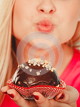 Cute blonde woman about to eat cupcake