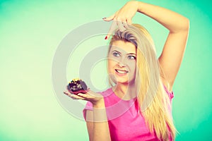 Cute blonde woman about to eat cupcake