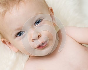 Cute blue eyed baby laying on a fluffy rug