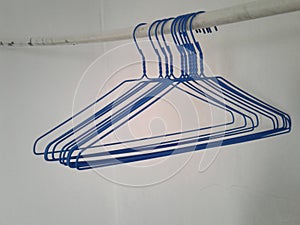 Cute blue hangers hangin on a white pipe photo