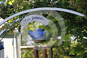 A cute blue teapot hangs the entrance to a tea garden, Ireland.