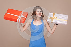 Cute boss demonstrate her gift boxes and smiling at camera