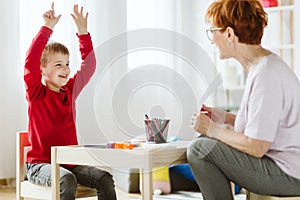 Cute boy with ADHD during session with professional therapist