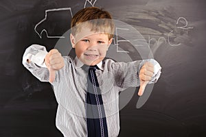 Cute boy against blackboard