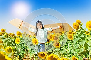 Cute boy aviator playing in sunflower field