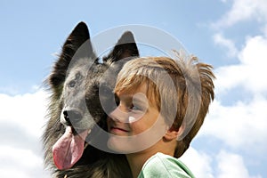 A cute boy with a Belgian shepherd