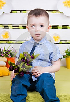 Cute boy in a blue denim shirt and tie, jeans and boots