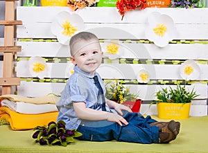 Cute boy in a blue denim shirt and tie, jeans and boots