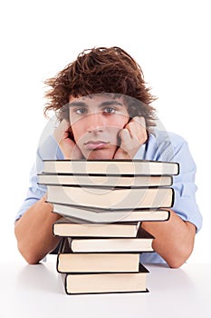 Cute boy bored, among books, on his desk