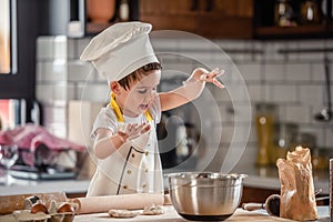 Cute boy chef cooking at home