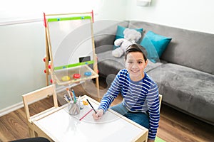 Cute boy coloring a book during his therapy session