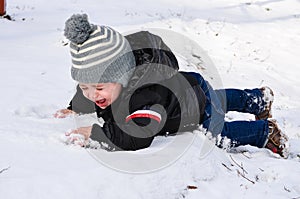 Cute boy crying in the snow