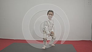 A cute boy dancing wildly on the red carpet in white background.