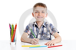 Cute boy drawing with colourful pencils