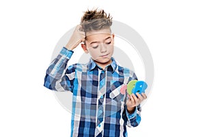 Cute boy with dyscalculia holding large colorful numbers and scratching his head. Learning disability concept.