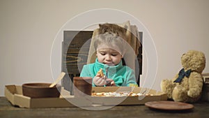 Cute boy eating pizza at home. Kids favorite food. Children food concept, happy hungry kid eat pizza.