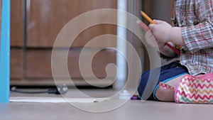 Cute boy in funny glasses draws with both hands on paper at home