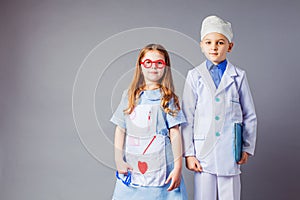 Cute boy and girl in medical uniform playing like doctors.