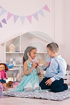 Cute boy and girl play doctor and patient, girl listens to boy`s heartbeat with stethoscope