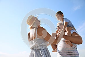 Cute boy with grandparents spending time together on sunny day outdoors