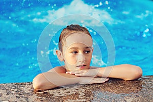 Cute boy having fun in the pool. Summer vacation concept. Water games and water fun for kids