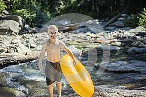 Cute Boy having fun riding an inflatable tube on a summers day photo