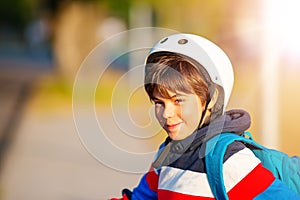 Cute boy in helmet standing and smiling at photocamera. photo
